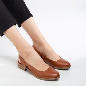 May include: A pair of brown leather heeled slingback shoes with a pointed toe.