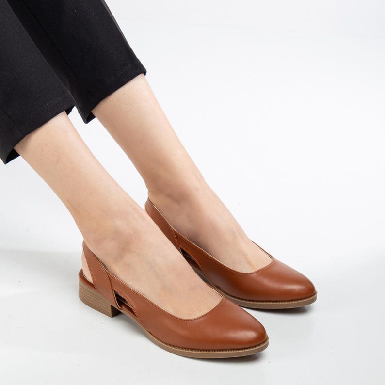 May include: A pair of brown leather heeled slingback shoes with a pointed toe.