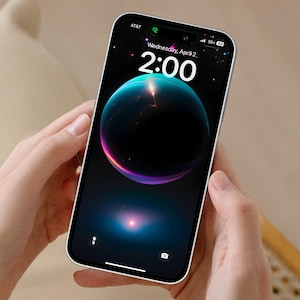 May include: A white iPhone with a black screen displaying a dark blue and purple sphere with a bright light in the center. The time is 2:00 and the date is Wednesday, April 2.