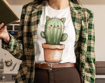 May include: White t-shirt featuring a graphic of a green cactus with a cat face. The cactus is in a brown pot. The t-shirt is being worn by a person with a green and white checked blazer.