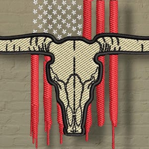 Puede incluir: Diseño bordado que presenta un cráneo de longhorn sobre una bandera estadounidense estilizada. El cráneo es beige con contornos negros, y la bandera tiene rayas rojas y estrellas blancas. El diseño se encuentra sobre un fondo texturizado similar a ladrillos.