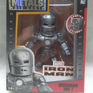 May include: A die-cast metal Iron Man figure in a box. The figure is silver and has a classic helmet design. The box features the Marvel Iron Man logo and the text "METALS DIE CAST". The packaging also includes the text "100% DIE-CAST METAL".