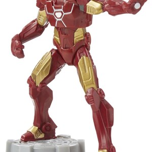Puede incluir: Una figura de acci&oacute;n de Iron Man roja y dorada. La figura est&aacute; en una pose din&aacute;mica, con un brazo extendido y el otro a su lado. La figura est&aacute; sobre una base gris. La armadura de la figura tiene detalles dorados.