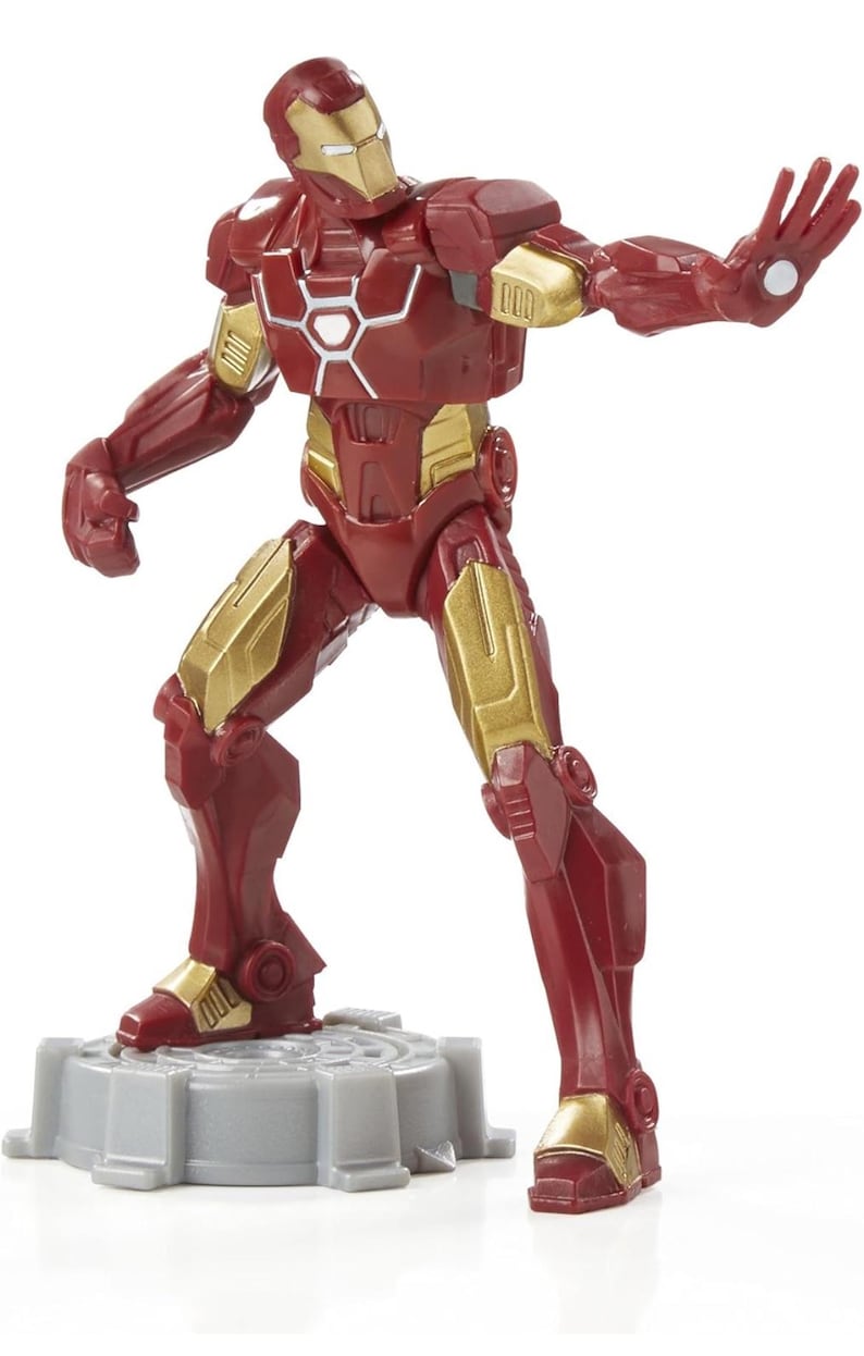 Puede incluir: Una figura de acci&oacute;n de Iron Man roja y dorada. La figura est&aacute; en una pose din&aacute;mica, con un brazo extendido y el otro a su lado. La figura est&aacute; sobre una base gris. La armadura de la figura tiene detalles dorados.