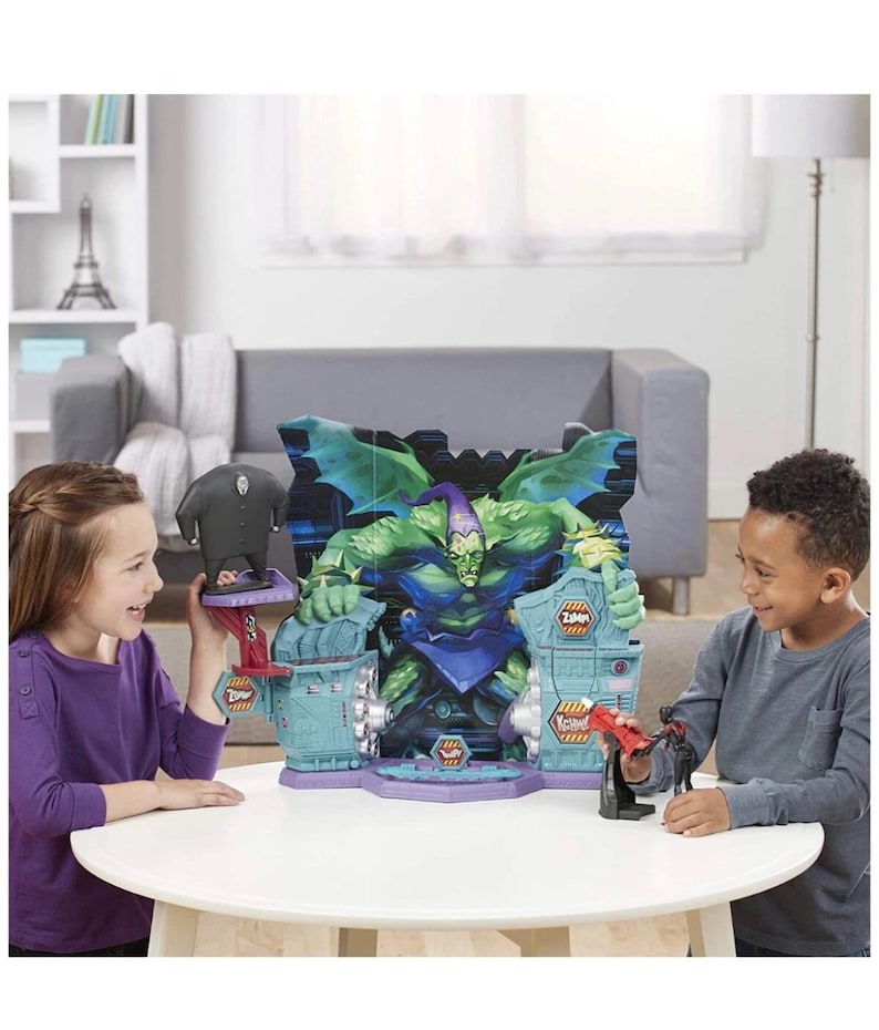 May include: A Green Goblin playset featuring a large Green Goblin figure with a purple and green color scheme. The playset has a blue and purple base with two children playing with the toys.