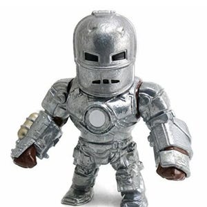 May include: A silver-colored Iron Man action figure. The figure is in a standing pose, with a helmet and armor. The figure has a round white circle on the chest. The figure is a collectible item.