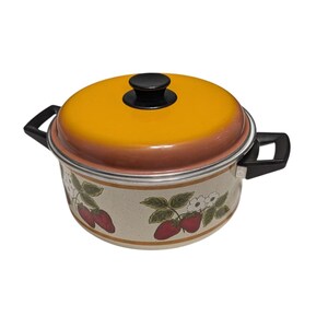 May include: A vintage cooking pot with a yellow lid and black handle. The pot has a cream-colored body with a strawberry and floral pattern. The lid has a black knob.