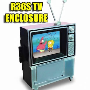 Puede incluir: Un recinto de TV en miniatura de estilo retro con el texto "R36S TV ENCLOSURE" en amarillo. La pantalla muestra una escena de dibujos animados con Bob Esponja y Patricio Estrella. El televisor tiene una parte superior rosa, una antena plateada y una base azul claro.