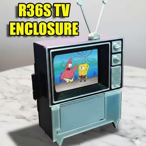 Puede incluir: Una peque&ntilde;a carcasa de TV con el texto "R36S TV ENCLOSURE" en amarillo. La pantalla muestra una caricatura con Bob Esponja y Patricio Estrella. La carcasa es negra con una parte superior rosa y una parte delantera azul claro.