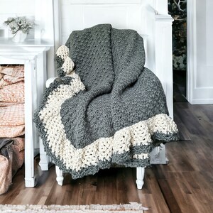 a crocheted blanket sits on a chair in front of a fireplace