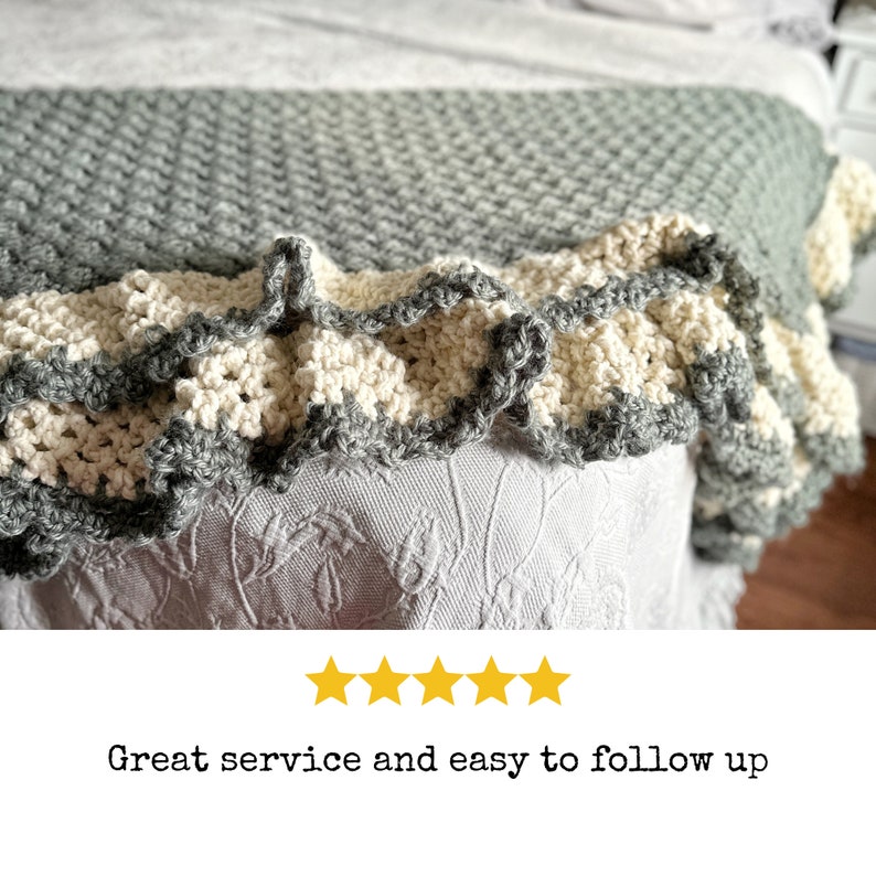 a green crocheted blanket  with cream crochet border sits on a bed