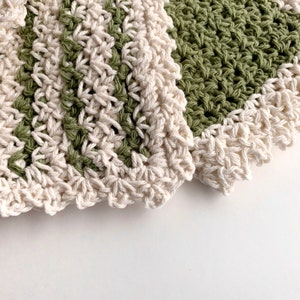 three crochet dishcloths that have a Lacey vintage farmhouse look cream, green with cream trim and green and cream striped with cream trim