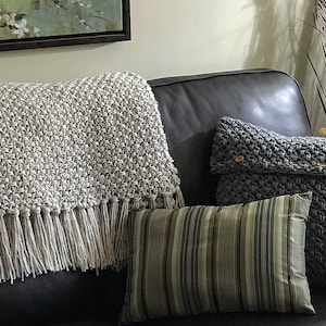 Beige crochet blanket with fringe that looks knit.  It is a throw size meaning it will cover legs and part of body not big enough for bed.  This is a crochet pattern not a finished item.