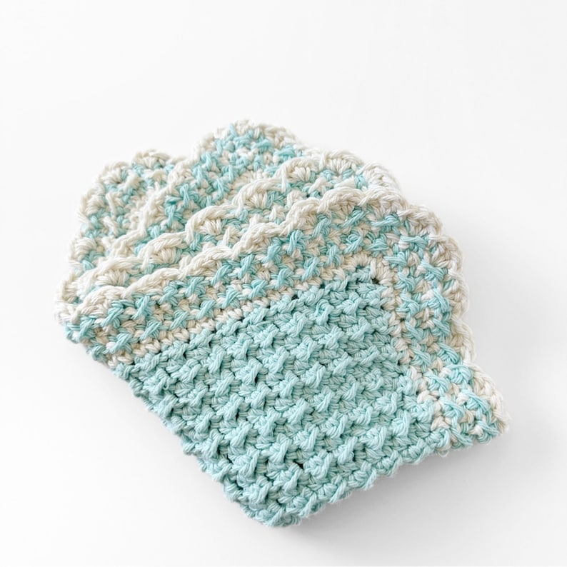 three crochet dishcloths made using the crochet crunch stitch clothes are in aqua cream and brown with a contrast border