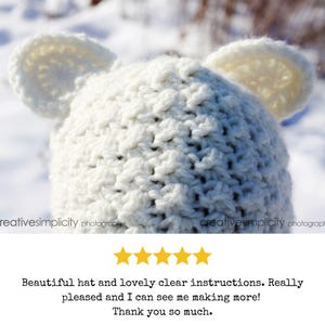 May include: White crocheted hat with bear ears. The hat is made with a textured stitch and is shown against a snowy background.