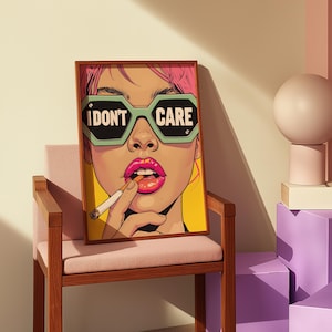 Könnte beinhalten: Gerahmter Kunstdruck mit einer Pop-Art-Illustration einer Person mit pinkfarbenem Haar und auffälligem Make-up. Die Person trägt grüne Sonnenbrillen mit der Aufschrift "I DON'T CARE". Eine Zigarette wird zwischen den Lippen gehalten.