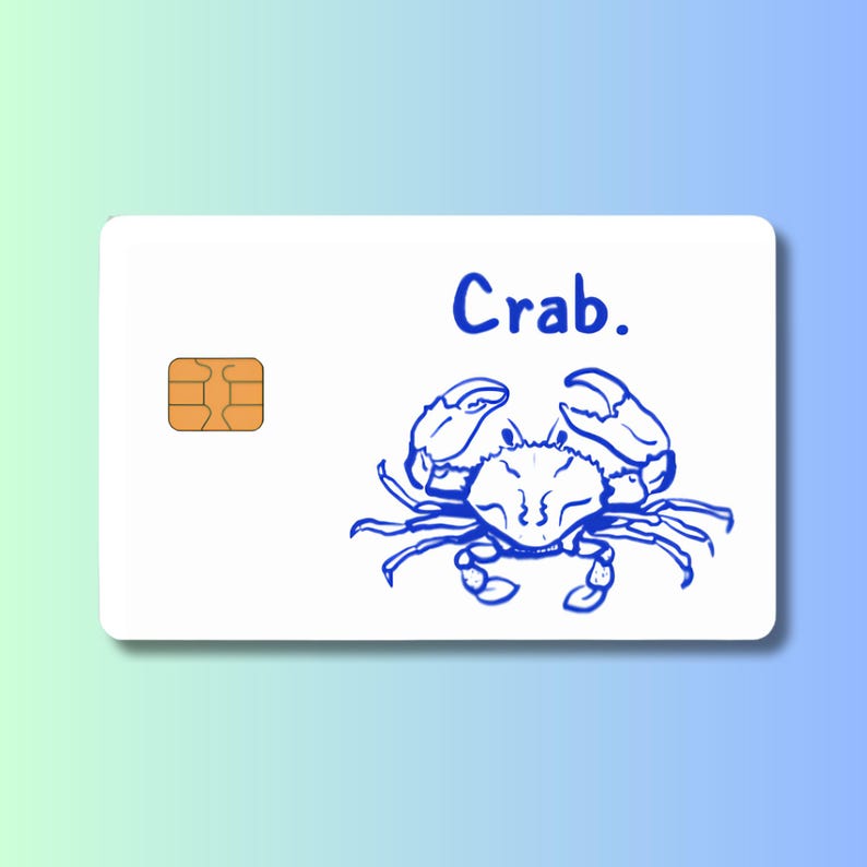 May include: A white card with a blue crab illustration and the word "Crab." The crab is drawn in a simple, cartoon style. An orange microchip is in the upper left corner.