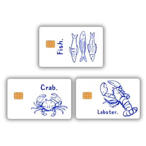 May include: Three white cards with blue illustrations of sea creatures. One card has three fish and the word "Fish.", another has a crab and the word "Crab.", and the last has a lobster and the word "Lobster."