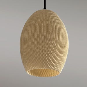 Puede incluir: Una lámpara colgante de color beige, de forma ovalada, con un patrón texturizado y tejido. La luz está suspendida de un cable negro.