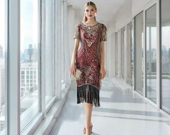 May include: A red and gold sequined dress with black fringe trim. The dress has a round neckline and short sleeves. The model is wearing the dress in a hallway with large windows.