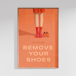 May include: An orange poster with the text "PLEASE REMOVE YOUR SHOES." The poster shows an illustration of legs wearing red polka dot socks and a pair of orange shoes. The words "KAISER OF SOCKS" are at the top.