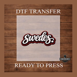 May include: DTF transfer with the word "Swedes" in a script font, outlined in black, red, and white. The words "DTF TRANSFER" and "READY TO PRESS" are above and below the design, respectively. The background is a wood grain pattern.