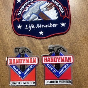 May include: A navy blue patch and two stickers featuring the "Handyman Club of America" logo. The patch reads "Life Member" and the stickers say "Charter Member". The logo includes a hammer and saw.