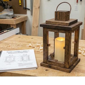 May include: A rustic wooden candle lantern with a handle, featuring a large, glowing, cream-colored candle inside. The lantern is made of stained wood and has clear glass panels. A woodworking plan titled "Rustic Candle Lantern Woodworking Plan" is visible.