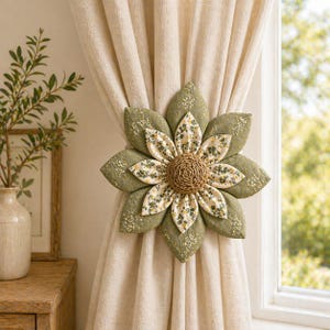 Puede incluir: Un recogedor de cortina floral decorativo con forma de flor grande. Los p&eacute;talos son de color verde oliva con un patr&oacute;n moteado, y el centro es tejido. Fijado a una cortina beige, a&ntilde;ade un toque decorativo a la habitaci&oacute;n.