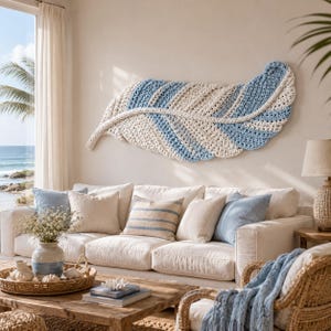 Pode incluir: Uma grande decora&ccedil;&atilde;o de parede horizontal em forma de pena, feita de corda tran&ccedil;ada espessa em listras alternadas de creme e azul claro. A pe&ccedil;a apresenta um eixo central e fibras texturizadas em la&ccedil;o que criam uma apar&ecirc;ncia suave e em camadas.