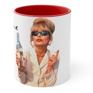 Puede incluir: Taza de cerámica blanca con interior rojo. Presenta a una mujer con gafas de sol sosteniendo una botella y un cigarrillo. La mujer lleva una blazer blanca y un collar dorado. La taza tiene el texto "...x" en el lateral.