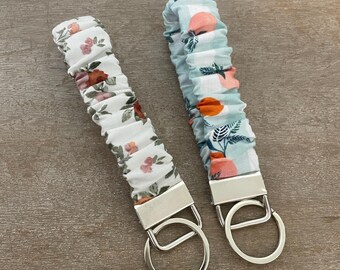 Llavero con coletero de tela: Estampados florales y de cuadros vichy color melocotón.