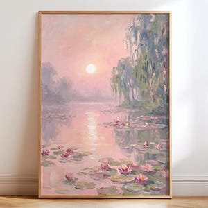 May include: A framed landscape painting shows a tranquil water scene with lily pads and pink flowers. The artwork uses a soft, pastel colour palette of pinks, purples, and greens, with a bright sun. The painting is in a wooden frame.