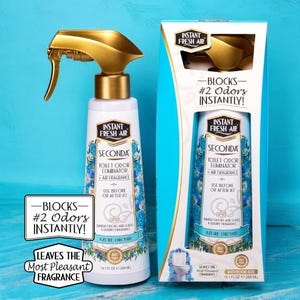 May include: A bottle of Secunda toilet odor eliminator and air fragrance in Azure Orchid scent. The bottle has a gold spray nozzle and is displayed with its packaging. The packaging reads "Blocks #2 Odours Instantly!"