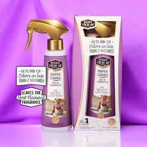 May include: A purple and gold diaper change odour eliminator spray bottle and box. The bottle has a gold spray nozzle and a label that reads "Instant Fresh Air" and "Diaper Change Odour Eliminator". The box has the same design and text.