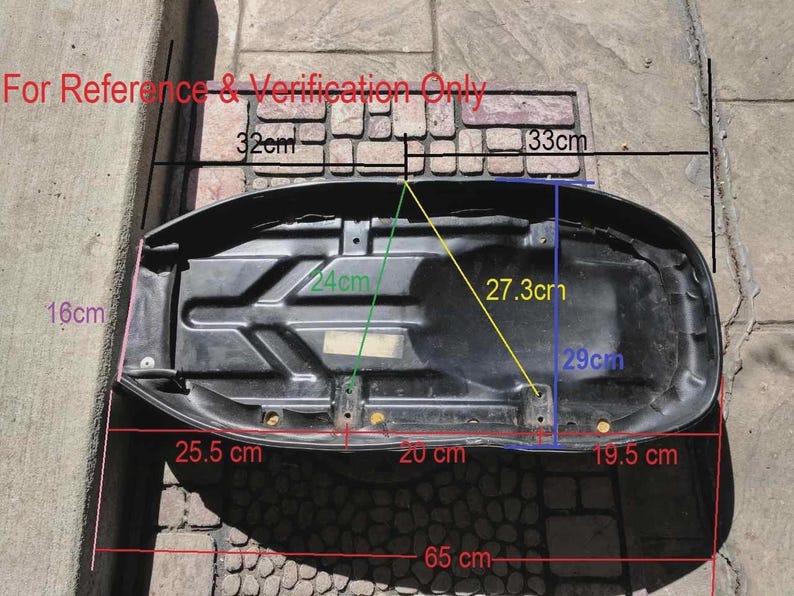 Peut inclure: Une selle de moto noire avec des mesures en centim&egrave;tres. La selle mesure environ 25,5 cm de large, 65 cm de long et 16 cm de haut. Le texte "For Reference & Verification Only" est visible.