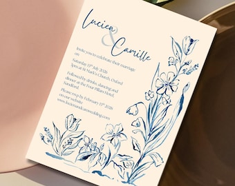 Puede incluir: Invitación de boda con los nombres "Lucien & Camille" en escritura elegante. La invitación presenta ilustraciones florales azules y texto que detalla la fecha, hora y lugar de la boda. También se incluye la dirección del sitio web.