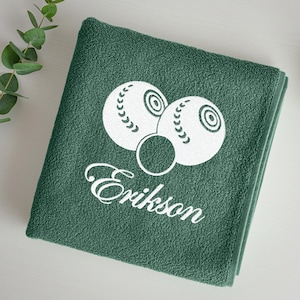 Puede incluir: Toalla verde oscuro plegada con un dise&ntilde;o blanco de bolas de bolos y el nombre "Erikson". La toalla est&aacute; hecha de un material suave y absorbente, ideal para el ba&ntilde;o o la playa. Dimensiones: aprox. 70 cm x 140 cm.