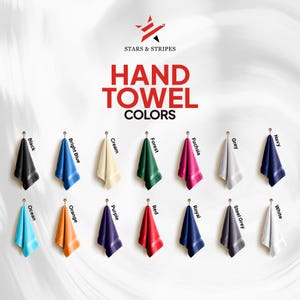 Puede incluir: Exhibici&oacute;n de toallas de mano en varios colores: negro, azul brillante, crema, verde bosque, fucsia, gris, azul marino, azul oc&eacute;ano, naranja, morado, rojo, azul real, gris acero y blanco. Las toallas cuelgan de ganchos. El texto dice "HAND TOWEL COLORS".