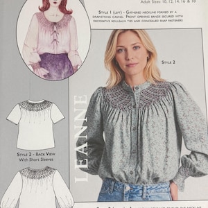 May include: A sewing pattern instruction sheet for the Meco Modes Leanne AD06 blouse. It features illustrations and photographs of a faux bishop round yoke blouse with smocked detailing, button-down front, and options for long or short sleeves.