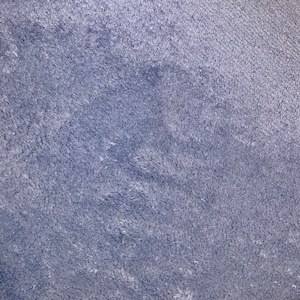 May include: A close-up of a soft, blue, fuzzy fabric. The fabric has a slightly textured surface.