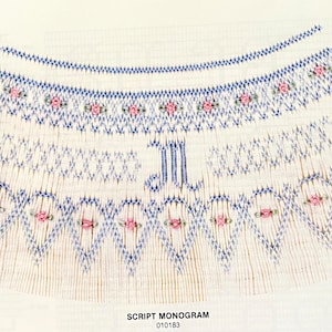 May include: A detailed illustration of a script monogram design. The design features a series of blue and white embroidered patterns, with pink floral accents. The letter "M" is prominently displayed. The text "SCRIPT MONOGRAM" and the number "010183" are also visible.