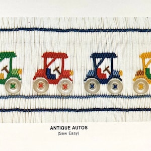 May include: A white fabric with blue stripes and four embroidered antique cars in green, red, blue, and yellow. The cars have black wheels and silver buttons. The text "ANTIQUE AUTOS (Sew Easy)" is printed below the cars. The text "Copyright in U.S.A." is printed in the bottom right corner.