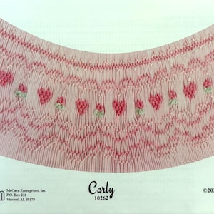 May include: A pink fabric pattern with a scalloped edge and a repeating heart design. The pattern is labeled "Carly 10262" and is from Ellen McCarn.