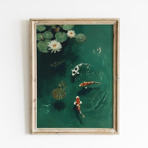 May include: Framed art print featuring a serene pond scene. The artwork depicts koi fish swimming in emerald green water, surrounded by lily pads and white water lilies. The frame is a light, natural wood color.