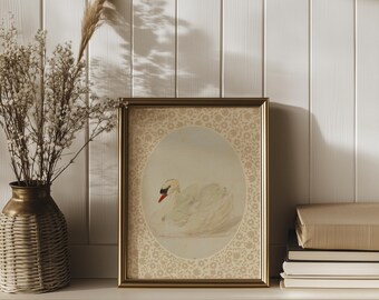May include: A framed print of a white swan with a red beak, set against a background of a delicate floral pattern. The frame is gold and has a simple, elegant design.