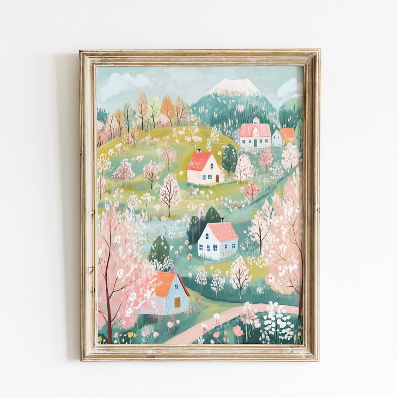 May include: A framed illustration of a whimsical village nestled in a green valley with blooming trees and colorful houses. The houses have red, blue, and white roofs and are surrounded by lush greenery and flowers.