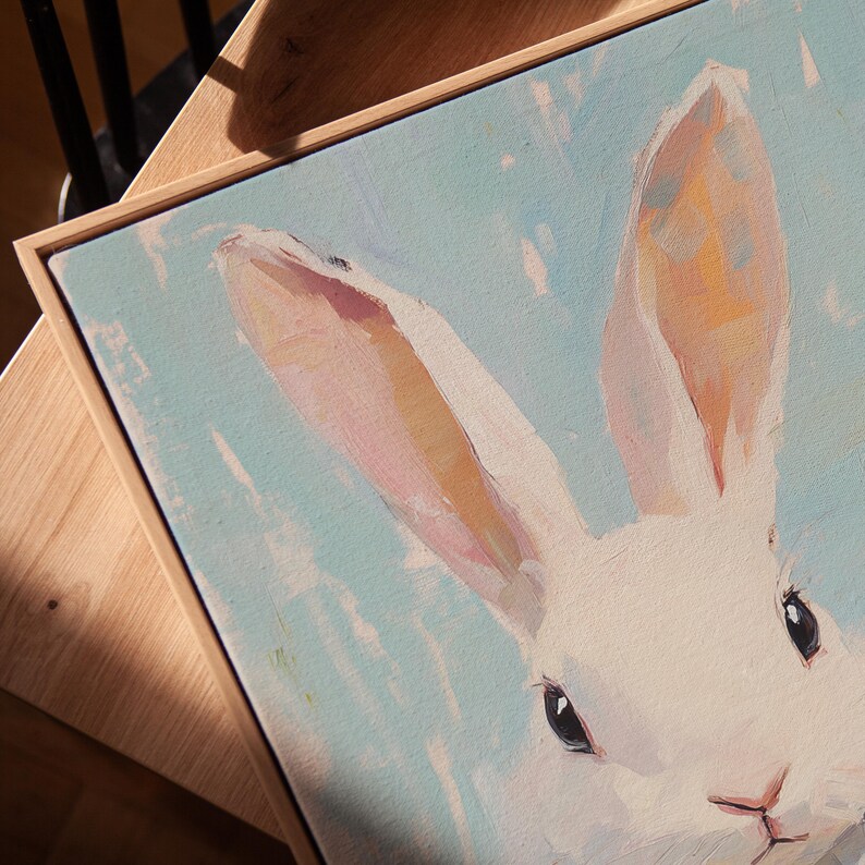 May include: A close-up of a white rabbit with pink ears and a blue background. The rabbit's eyes are black and its nose is pink.