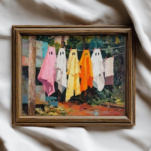 May include: A framed painting depicts colorful ghost-shaped figures hanging on a clothesline. The ghosts are in shades of pink, white, yellow, and orange, with black dot eyes. The background shows a green, impressionistic landscape.