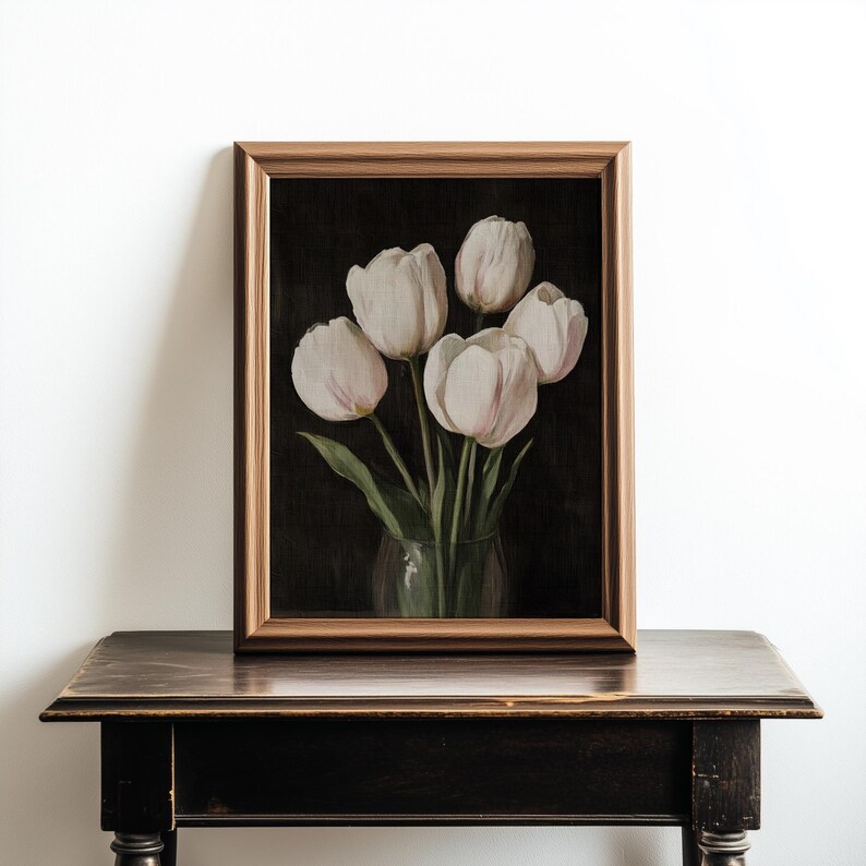 K&ouml;nnte beinhalten: Ein gerahmtes Gem&auml;lde mit einem Strau&szlig; wei&szlig;er Tulpen in einer durchsichtigen Glasvase vor einem dunklen Hintergrund.